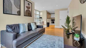 A modern living room with a sofa, a coffee table, and a TV stand.