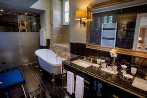 A modern bathroom with a freestanding bathtub, a large mirror, and a vanity with a black countertop. - Solar do Requeijo by Luna Hotels & Resorts (Giela)