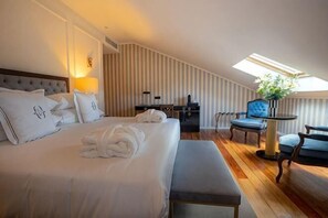 A hotel room with a large bed, a desk, a chair, and a small table with a vase. - Solar do Requeijo by Luna Hotels & Resorts (Giela)