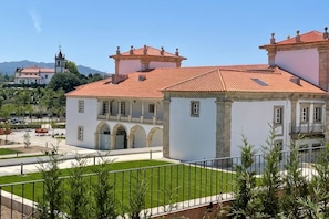 A building with a red-tiled roof, a courtyard, and a clear sky. - Solar do Requeijo by Luna Hotels & Resorts (Giela)