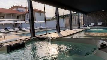 Un área de piscina con sillones de descanso y un jacuzzi.