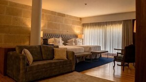A hotel room with a bed, a sofa, a small table, and a chair. - Solar do Requeijo by Luna Hotels & Resorts (Giela)
