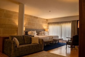 Ein Hotelzimmer mit einem Bett, einem Sofa, einem kleinen Tisch und einem Sessel.