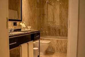 A bathroom with a marble wall, a sink, a toilet, and a shower area. - Solar do Requeijo by Luna Hotels & Resorts (Giela)