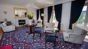 Una habitación con chimenea, candelabro y alfombra estampada.