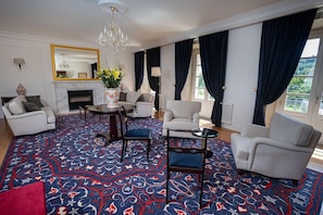 Una habitación con chimenea, candelabro y alfombra estampada.