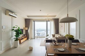 Una habitación de hotel moderna con comedor, un ventanal y vistas a la ciudad.