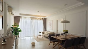 A modern living room with a dining area, a sofa, a coffee table, and a chandelier. - Diamond Island Highfloor RiverView 8min to D1 (Ho Chi Minh City)