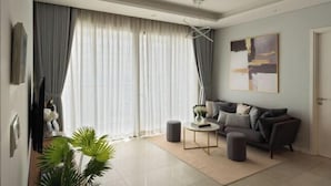 A modern living room with a sofa, ottoman, and a coffee table. - Diamond Island Highfloor RiverView 8min to D1 (Ho Chi Minh City)