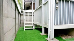 A small, enclosed outdoor area with artificial green turf, a white metal structure, and a grey building in the background. - Shinjuku 11 mins Private kitchen and bathroom Up to 4 guests Newly renovated Garden villa (Tokyo)