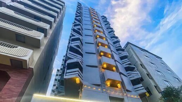 A high-rise building with multiple balconies, a modern architectural design, and a clear sky in the background. - Shinjuku 11 mins Private kitchen and bathroom Up to 4 guests Newly renovated Garden villa (Tokyo)