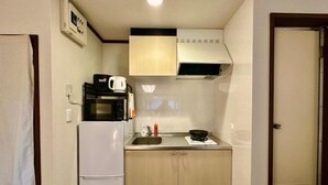 A compact kitchen with a microwave, a coffee maker, and a sink. - Shinjuku 11 mins Private kitchen and bathroom Up to 4 guests Newly renovated Garden villa (Tokyo)