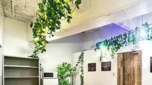A conference room with a wooden table, black chairs, a whiteboard, and green plants. - Shinjuku 11 mins Private kitchen and bathroom Up to 4 guests Newly renovated Garden villa (Tokyo)