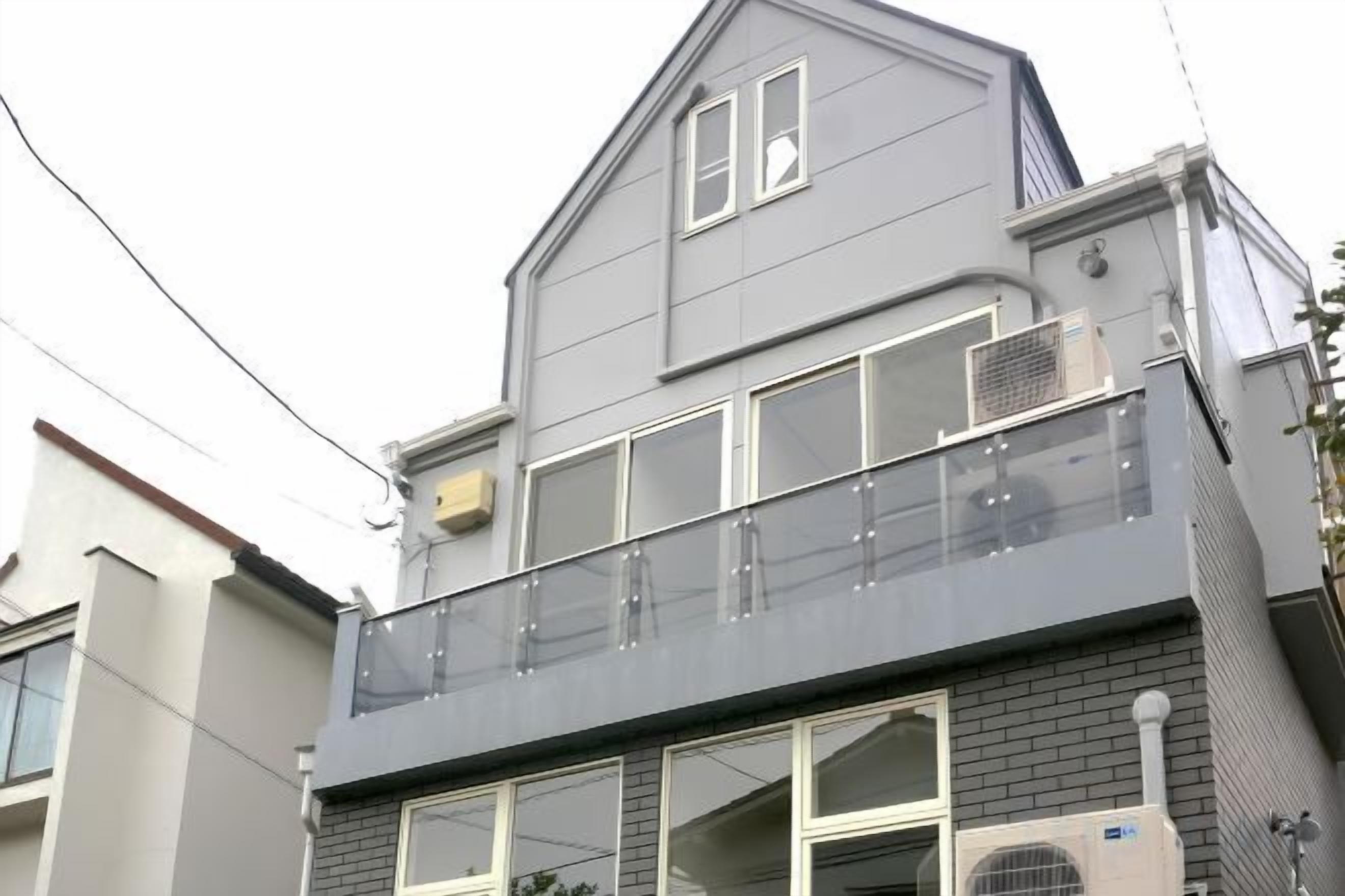 A two-story residential building with a balcony on the upper floor.