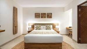 A bedroom with a large bed, bedside tables, a wooden headboard, and wall-mounted artwork. - Villa Surya by BaliSuperHost (Bali)