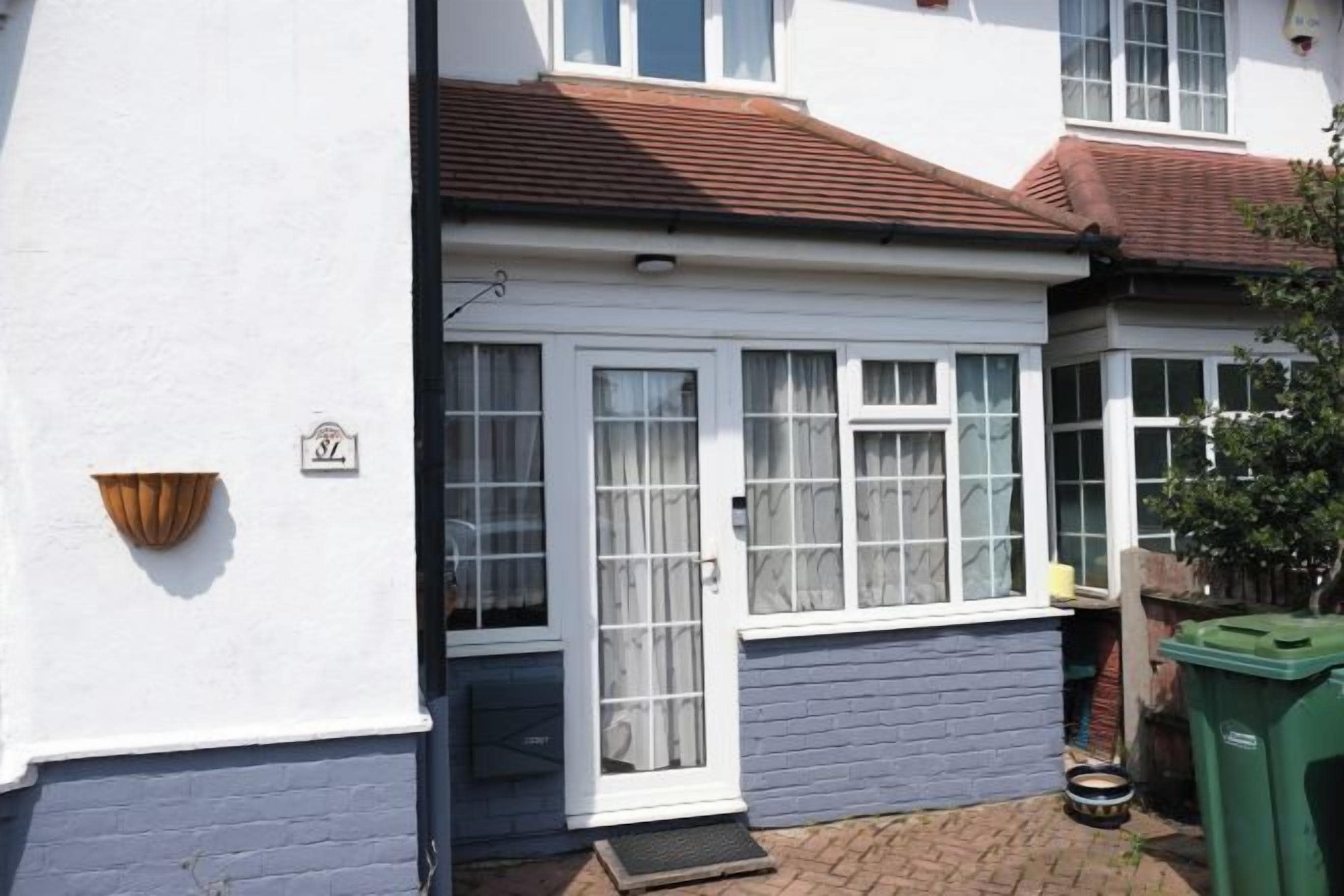 A residential property with a front door, windows, and a small porch area.