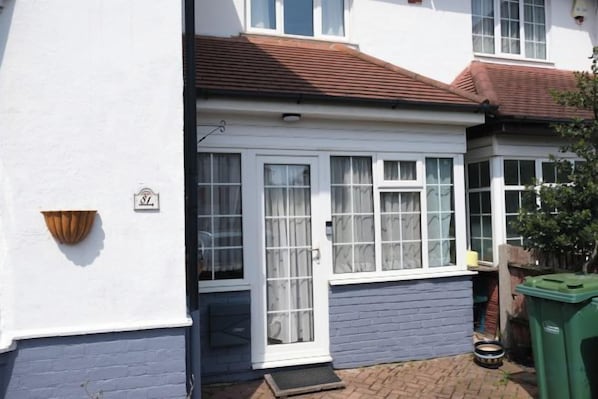 A residential property with a front door, windows, and a small porch area.