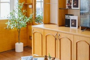 A wooden cabinet with a plant, a magazine, and a framed picture. - VietHOME - 22 Pho Hue - Apartment 401 (Hanoi)