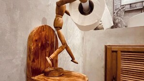 A wooden sculpture of a figure with a circular base, mounted on a wall. - Destination 39 Pool Villa (Phuket)