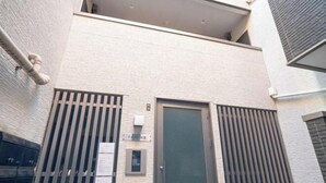 A building with a metal gate, a door, and a small window with a sign. - New open！F Maison Kishinosato｜Next to Tenga Chaya Park (Osaka)