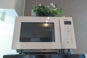 A microwave oven with a digital display and control panel, placed on a stand. - New open！F Maison Kishinosato｜Next to Tenga Chaya Park (Osaka)