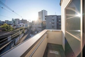 A narrow urban street with buildings, a clear sky, and sunlight. - New open！F Maison Kishinosato｜Next to Tenga Chaya Park (Osaka)