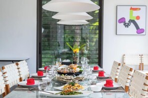 A dining table set with plates, glasses, and a centerpiece. - Luxury Beachfront Villas & Resort (Phuket)