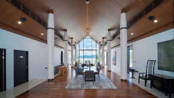 A spacious hotel lobby with a high ceiling, wooden beams, and a central seating area.