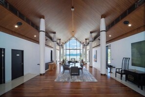 A spacious hotel lobby with a high ceiling, wooden beams, and a central seating area. - Luxury Beachfront Villas & Resort (Phuket)