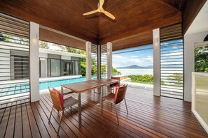 Une terrasse en bois avec une piscine, une table et des chaises.