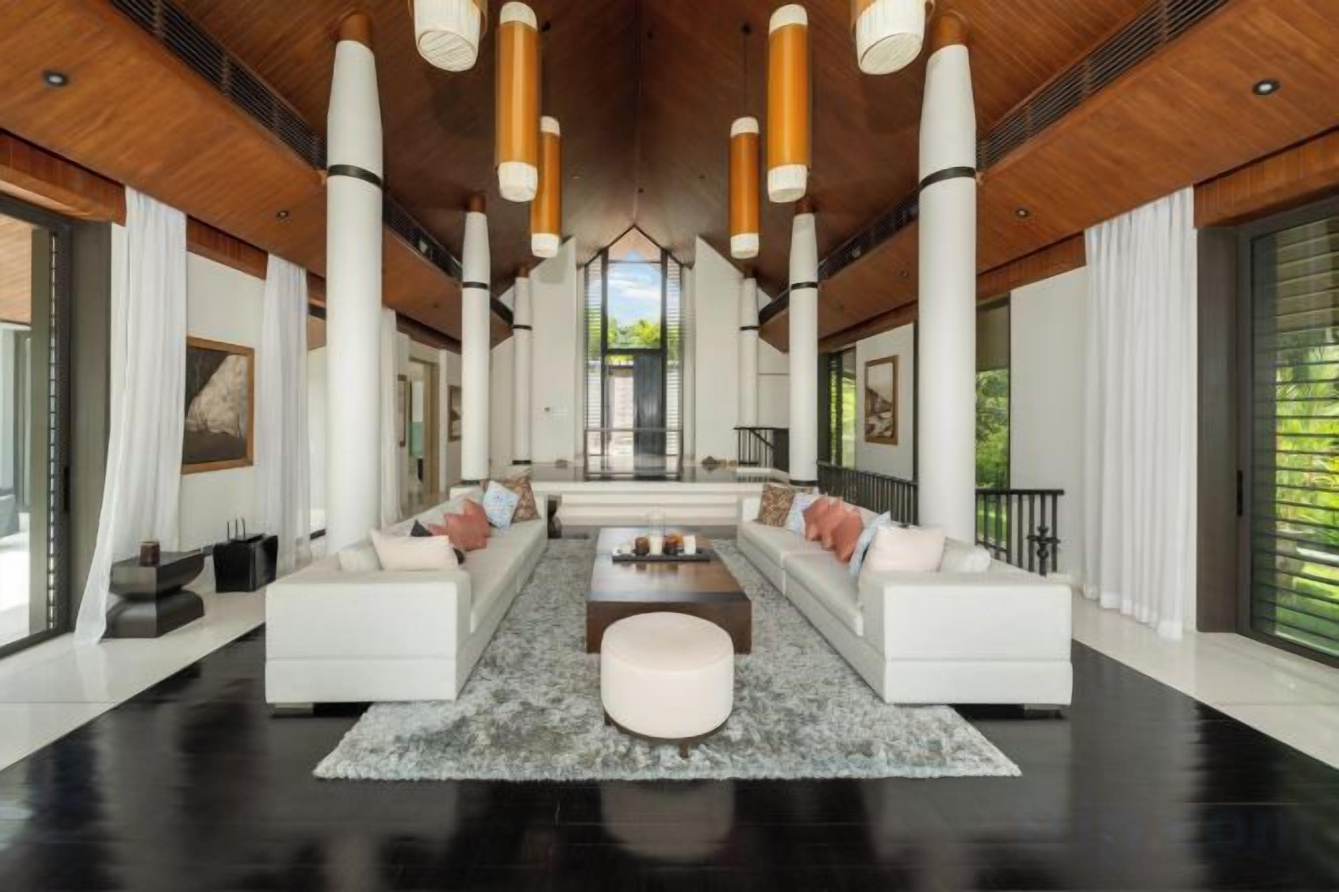 A spacious living room with a large sofa set, a coffee table, and a fireplace.