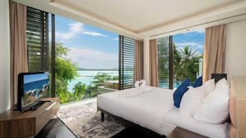 A hotel room with a large bed, a TV, and a balcony with a view of the sea.