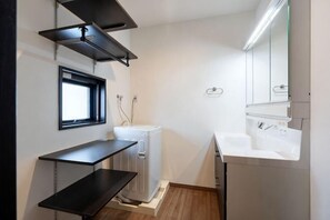 Een kleine keuken met een inbouwkoelkast, een spoelbak en een raam.