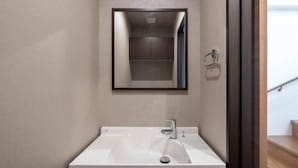 A bathroom with a white sink, a mirror, and a wooden staircase in the background. - KAIGAN HAJIME HUB (Tokyo)