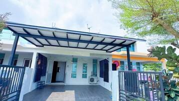 A covered outdoor area with a metal roof, a paved entrance, and a gated entrance.