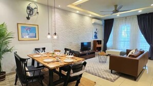 Una sala de estar moderna con una mesa de comedor, sillas, un sofá, un televisor y un ventilador de techo.
