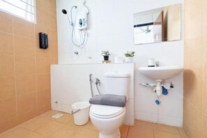 Un baño con inodoro, bidé, lavabo y espejo.