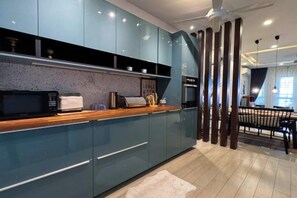 A modern kitchen with a microwave, toaster, and coffee maker on the counter. - Bangi Avenue Charming 4BR Blissful Double Storey (Kajang)