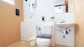 Un baño con inodoro, bidé, lavabo y espejo.