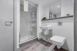 A modern bathroom with a glass shower enclosure, a white sink, and a toilet. - Host & Stay The Roscoe Nest (Liverpool)