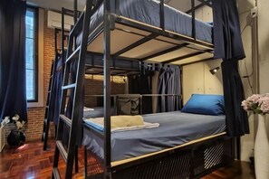 A bunk bed with a ladder, a small table, a chair, and a vase with flowers. - MEEMAW'S HOUSE (Bangkok)