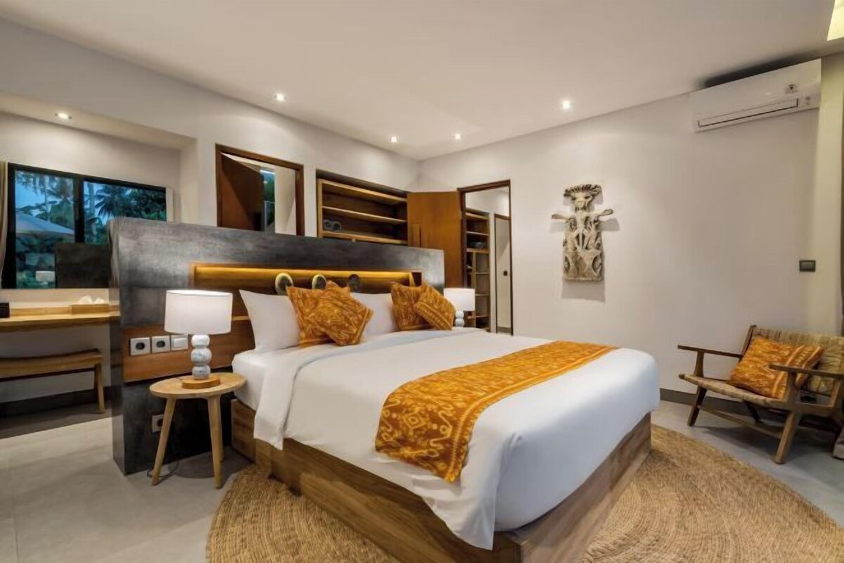 Une chambre moderne avec un grand lit, des tables de chevet, un bureau et une chaise.