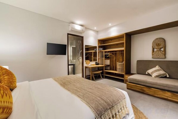 A hotel room with a bed, a desk, a wardrobe, and a sofa. - Villa Golden Lion by BaliSuperHost (Bali)
