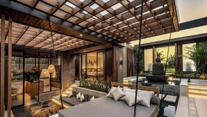 A modern outdoor living area with a pool, seating, and a pergola.