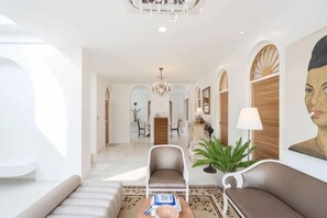 A spacious living area with a sofa, armchairs, a coffee table, and a chandelier. - Arpo Pool Villa Riverside Bangkok (Bangkok)