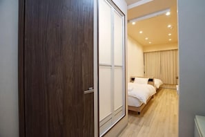 Ein Schlafzimmer mit einem Holzschrank, einem Bett mit weißer Bettwäsche und einer Deckenleuchte.