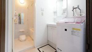 A modern bathroom with a shower, toilet, and a sink with a mirror.