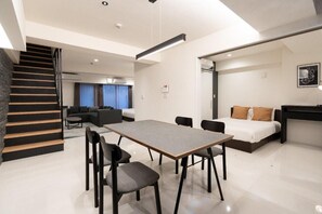 A modern hotel room with a dining area, a bed, and a staircase. - CREAL premier Akasaka (Minato-ku)