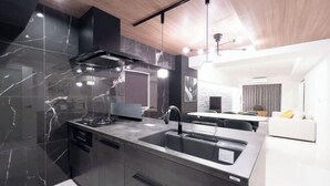 A modern kitchen with a large island, stainless steel appliances, and a sleek design. - CREAL premier Akasaka (Tokyo)