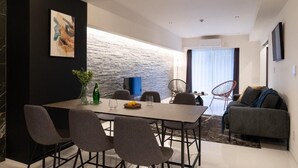 Un espacio moderno de estar con comedor, sofá y televisor.
